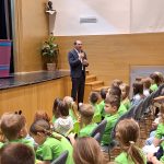 Otroci v zelenih majicah &raquo;Že berem sam&laquo; zbrano poslu&scaron;ajo nagovor župana Du&scaron;ana Strnada, ki je ob zaključku projekta Zeleni bralci poudaril pomen branja ter spodbudil mlade k nadaljnjemu odkrivanju sveta knjig.