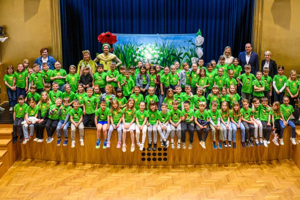 Učenci v zelenih majicah z napisom &raquo;Že berem sam&laquo; so z navdu&scaron;enjem z organizatorji projekta.