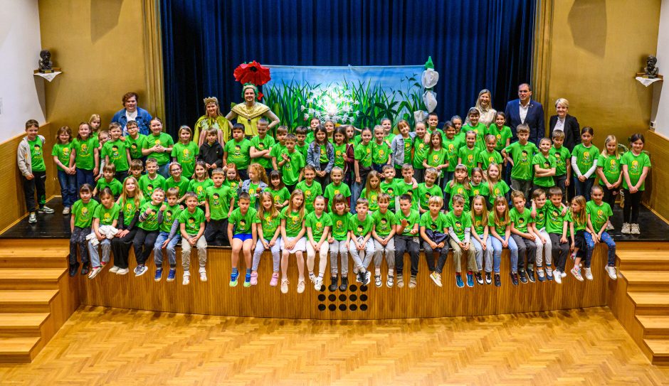 Učenci v zelenih majicah z napisom &raquo;Že berem sam&laquo; so z navdu&scaron;enjem z organizatorji projekta.